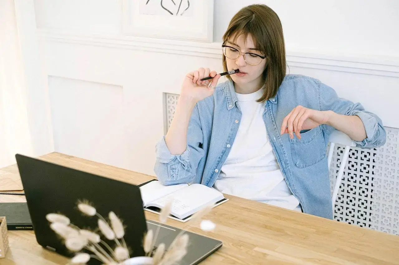Amazon seller sitting at her laptop while working on creating a blog article.